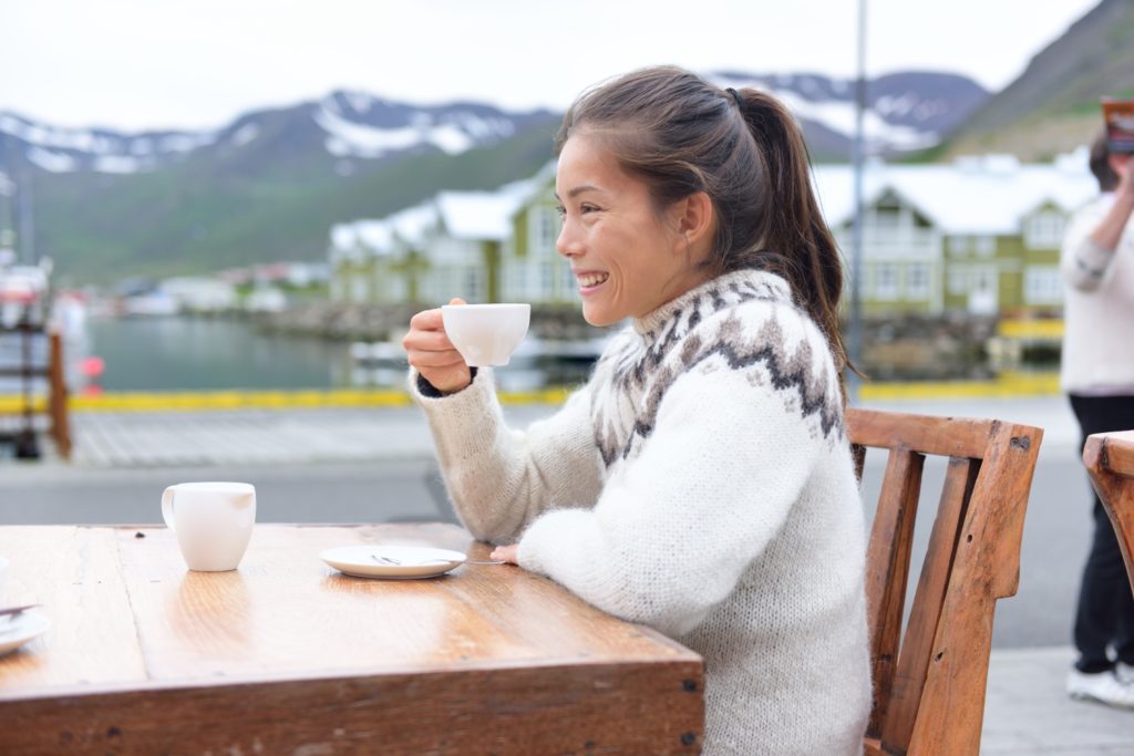 woman drinking coffee on sidewalk cafe on Iceland